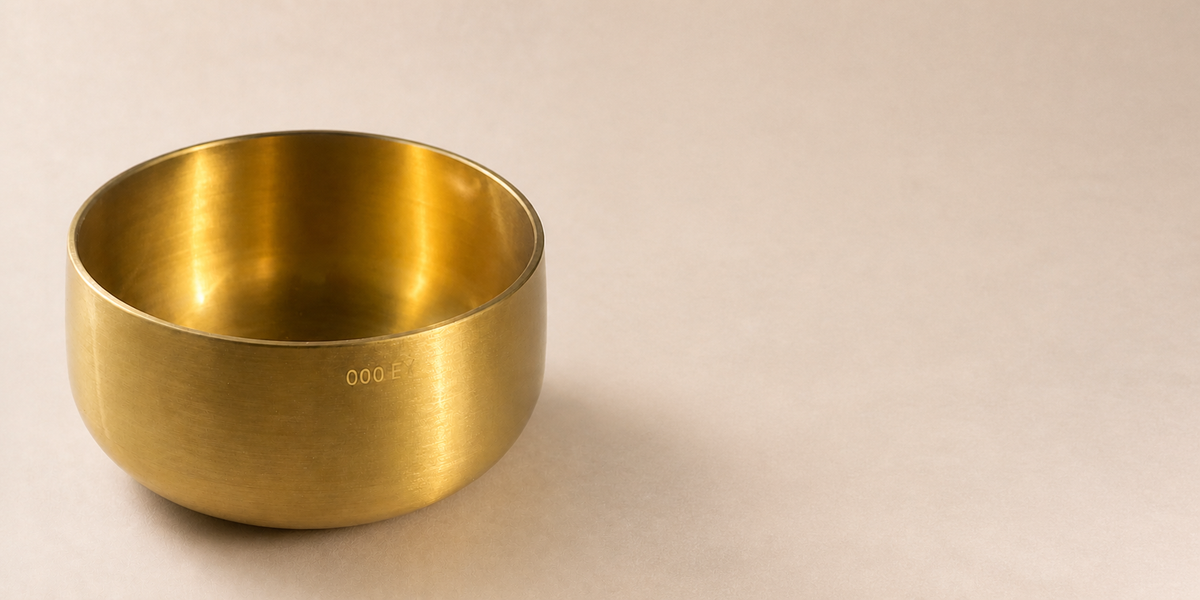 Engraved brass singing bowl on a warm neutral background