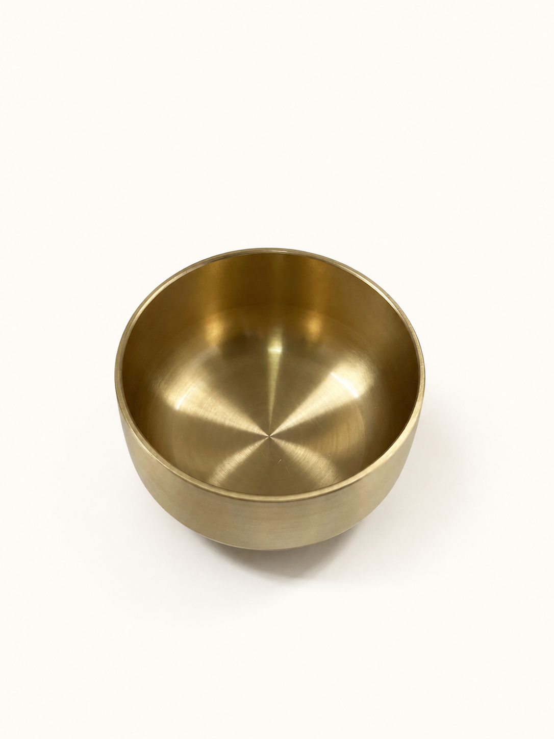 Brass singing bowl from above, showing the brushed interior and rounded base