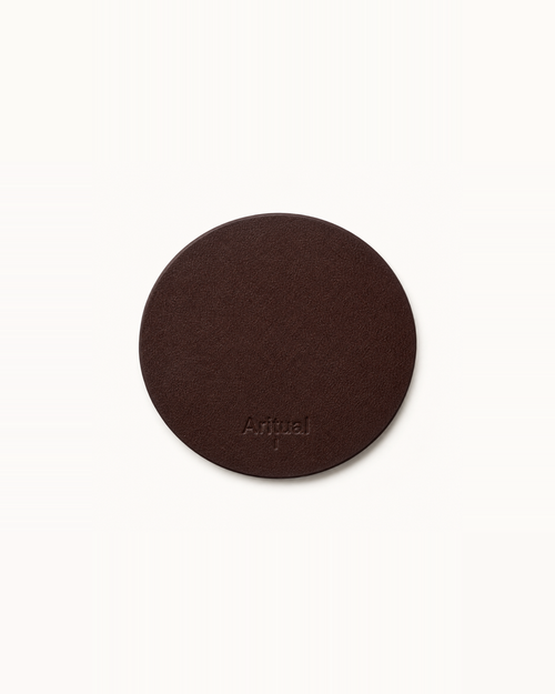 Aritual singing bowl pad in deep brown leather, debossed with the Aritual mark