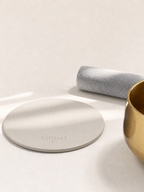 Ivory leather pad beside the brass singing bowl and suede mallet
