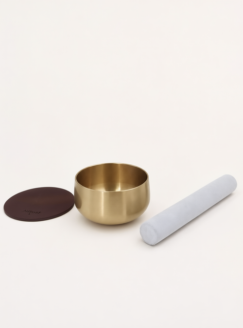 Singing Bowl Set laid out — brass bowl, suede mallet and deep brown leather pad
