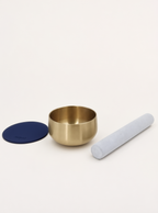 Singing Bowl Set laid out — brass bowl, suede mallet and navy blue leather pad