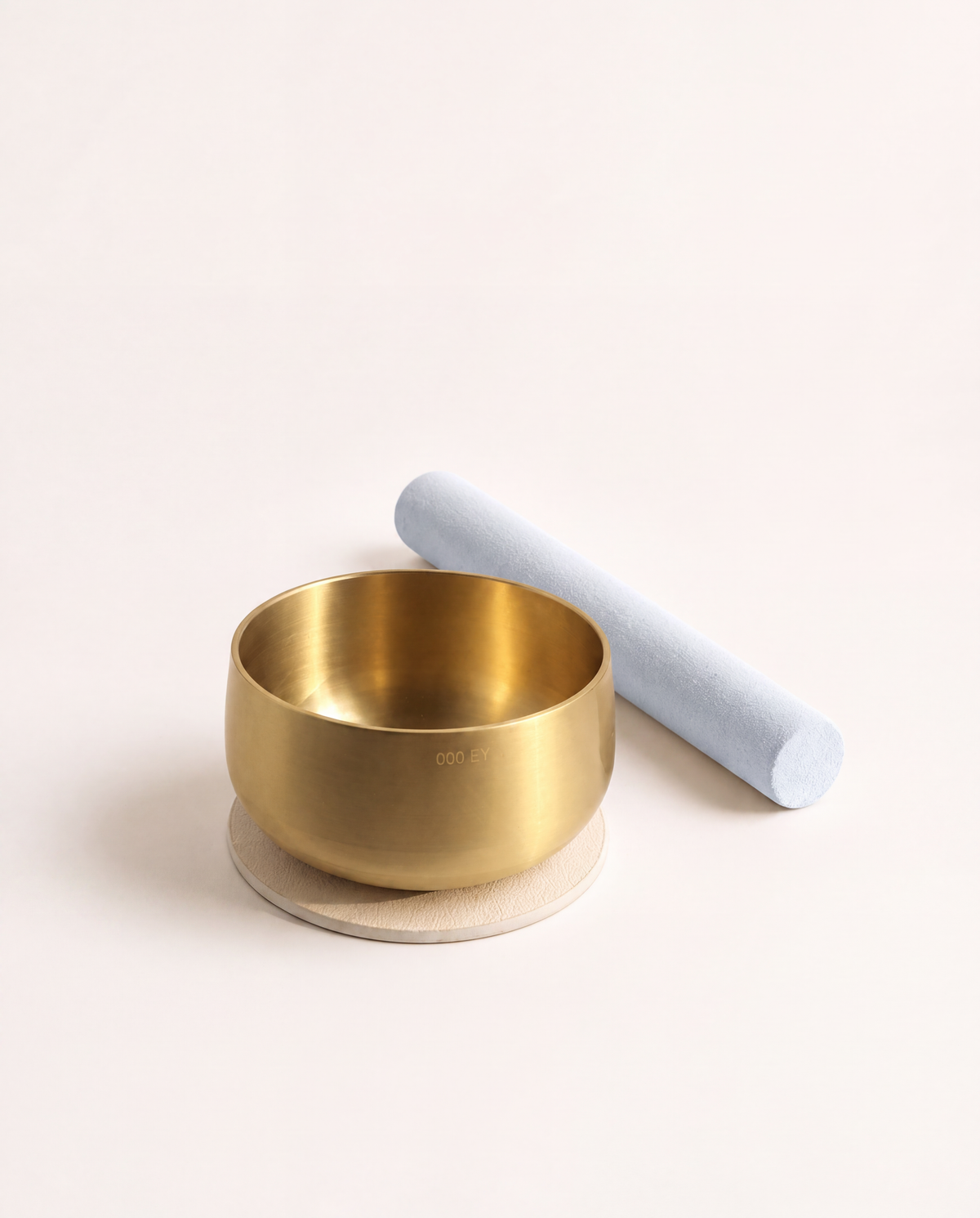 Engraved brass bowl seated on the ivory pad with the mallet alongside